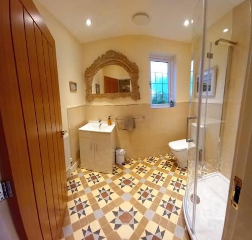 La salle de bains est pourvue de toilettes, d'un lavabo et d'une douche. dans l'établissement No 4 suite, à Lyme Regis