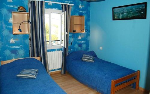 een slaapkamer met 2 bedden en blauwe muren bij Maison de 4 chambres avec vue sur la ville jacuzzi et jardin clos a Castelnau Montratier in Castelnau-de-Montratier