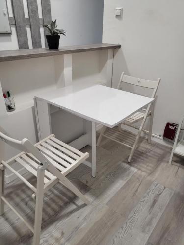 einen weißen Tisch und Stühle in einem Zimmer in der Unterkunft Stilvolle Wohnung in Wuppertal inkl. Kaffee & Tee in Wuppertal