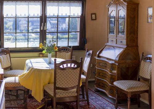 a dining room with a table and chairs and windows at FerienSchlösschen Zell in Zell an der Mosel