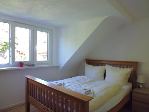 a bed in a room with two windows at Mosel Ferienhaus Zell in Zell an der Mosel