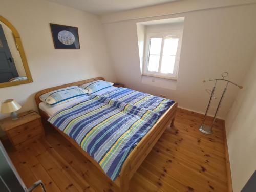 um quarto com uma cama com lençóis azuis e uma janela em Kleine Glocke 2 em Merl