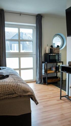 a bedroom with a bed and a large window at Industrialdesign Düren in Düren - Eifel