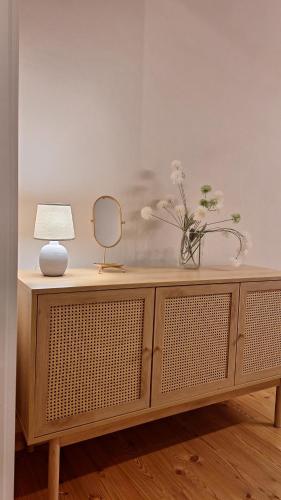 a wooden cabinet with a mirror and a lamp on it at Stadtpalais Romantik-Suite 3 Zimmer maximal 6 Personen in Bautzen