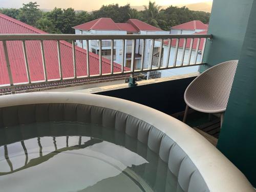 a balcony with a pillow and two chairs on a building at APPART SPA 20 MIN port croisière et aéroport in Sainte-Rose