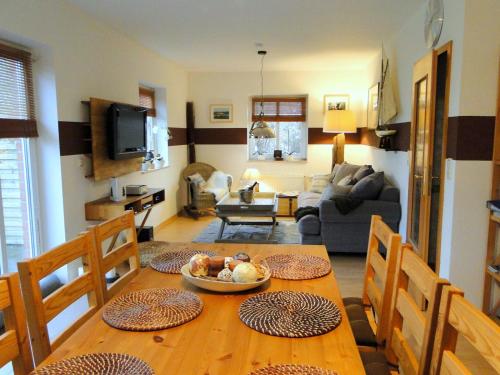 eine Küche und ein Wohnzimmer mit einem Holztisch in der Unterkunft Apartments Kirsebek in Kappeln
