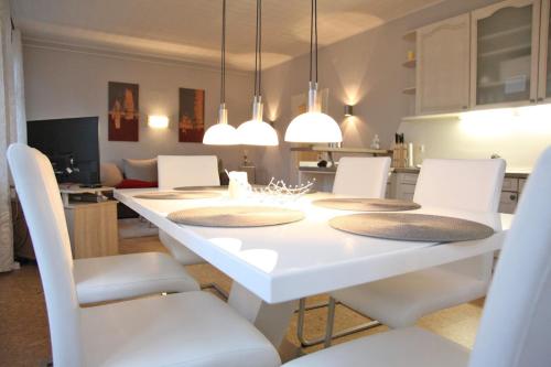 a dining room with a white table and white chairs at Seestern in Kappeln