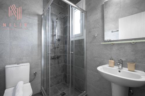 a bathroom with a shower and a sink and a toilet at Ouranos, Nilie Hospitality MGMT in Nikiti