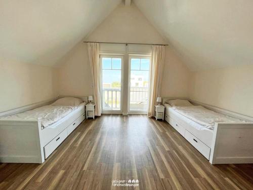 a large room with two beds and a window at Misfit in Olpenitz