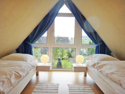 a bedroom with two beds and a large window at Rosenhaus in Kappeln