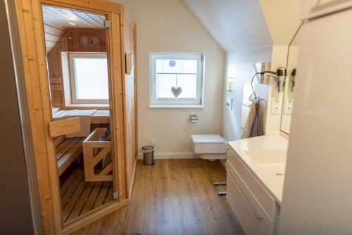 オルペニッツにあるHus im Lee un Luvのバスルーム(洗面台、トイレ付)、窓が備わります。