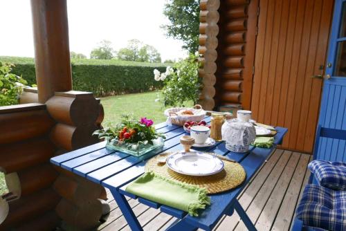 a blue table on a porch with a plate of food at Mein Blockhaus in Hasselberg