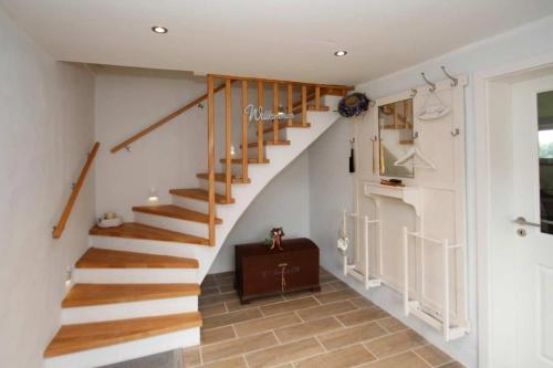 eine Treppe in einem Haus mit weißen Wänden in der Unterkunft Aschenputtel in Brarupholz