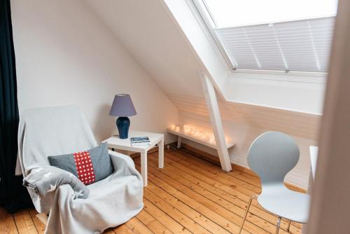 Zimmer im Dachgeschoss mit einem Stuhl und einem Fenster in der Unterkunft Altes Kapitänshaus in Arnis