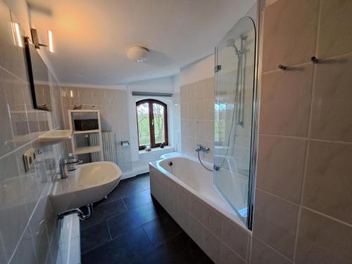 a bathroom with a tub and a sink and a shower at Naturnahes Ostsee und Schlei Erlebnis im Landhaus Grüne Oase an der Geltinger Bucht in Stangheck