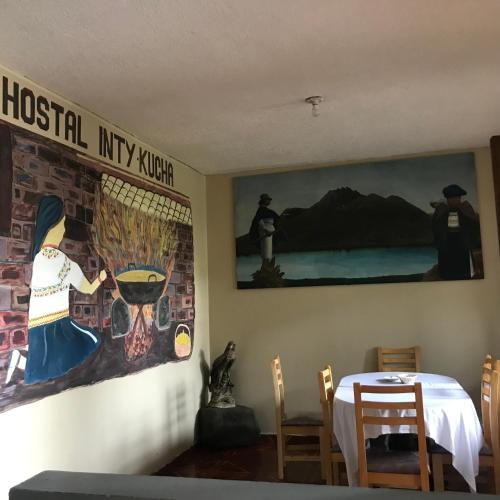 奧塔瓦洛的住宿－Intykucha，一间设有桌子和墙上绘画的用餐室