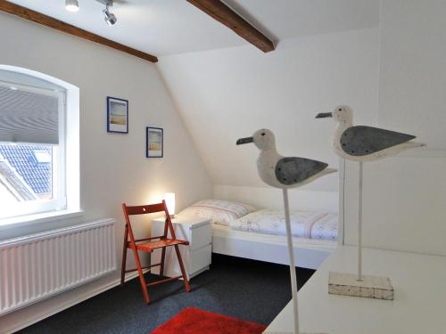 a room with a bedroom with a bed and two toy ducks at Skrey's To Hus in Kappeln