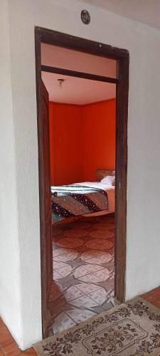 a doorway into a bedroom with a bed in a room at Intykucha in Otavalo