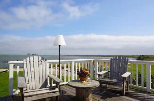 two chairs and a table on a deck with the ocean at Thor's Schleilounge in Olpenitz