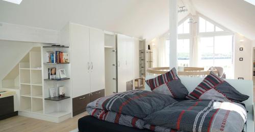 a living room with a bed and a book shelf at Thor's Schleilounge in Olpenitz
