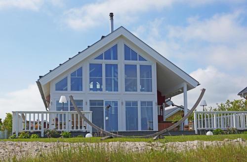 a house with a large window on a beach at Thor's Schleilounge in Olpenitz