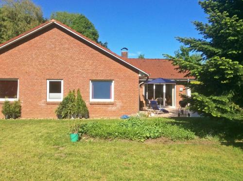 a red brick house with a yard at Schleiglanz in Ulsnis