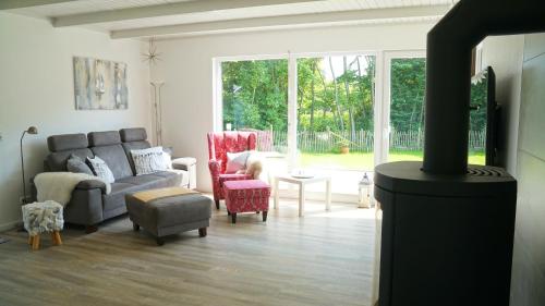 a living room with a couch and chairs and a fireplace at Schmidt's Huus in Damp