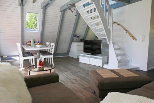 sala de estar con escalera y mesa con TV en Zum Kuhfleck en Damp