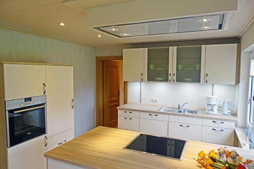a kitchen with white cabinets and a wooden counter top at Mee(h)r in Hasselberg