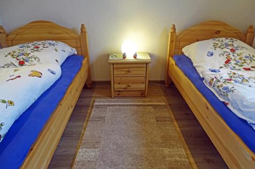 two twin beds in a room with a night stand at Mee(h)r in Hasselberg