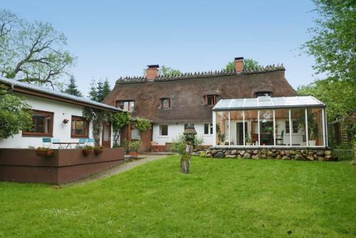 a man standing in a yard in front of a house at Schöne von Angeln in Saustrup