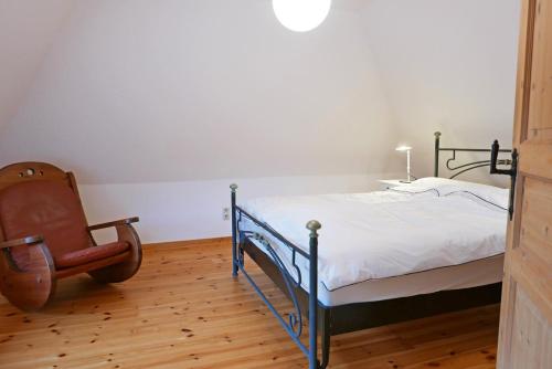 1 dormitorio con 1 cama y 1 silla en Schöne von Angeln, en Saustrup