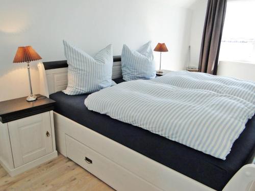 a bed with blue and white sheets and pillows at Flow in Kappeln