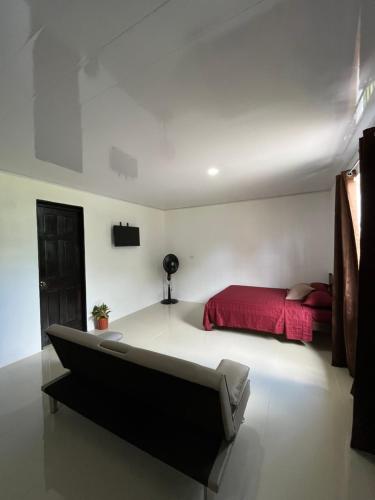 een slaapkamer met een bed en een rood bed sidx sidx sidx sidx bij Corcovado House With AC in Puerto Jiménez