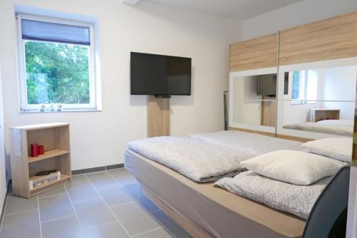 a bedroom with a bed and a flat screen tv at Ferienhaus Richter in Lindau