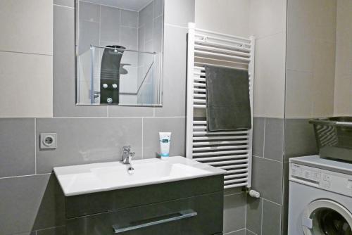 a bathroom with a sink and a washing machine at Ferienhaus Richter in Lindau