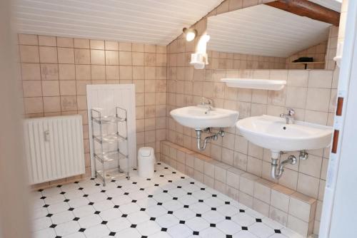 La salle de bains est pourvue de deux lavabos et de carrelage. dans l'établissement Schleimuschel, à Kappeln