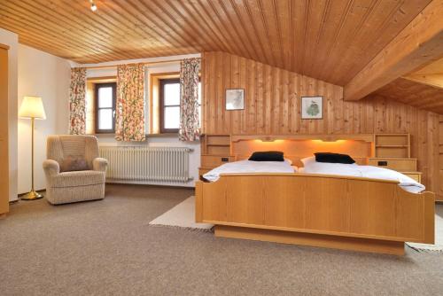1 dormitorio con 1 cama grande y techo de madera en Gut Fallenstein, en Bayerisch Gmain