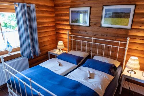 a bedroom with two beds in a log cabin at Ferienhaus Dat smuke Swedenhuus in Kappeln