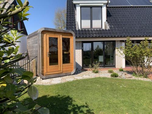 a house with a wooden door in a yard at Vincent in Kappeln