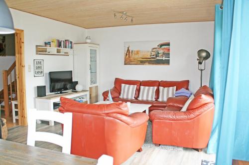 uma sala de estar com dois sofás e uma televisão em Pippilotta em Kronsgaard