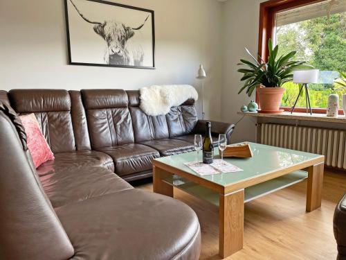 a living room with a brown leather couch and a table at Stadtoase in Süderbrarup