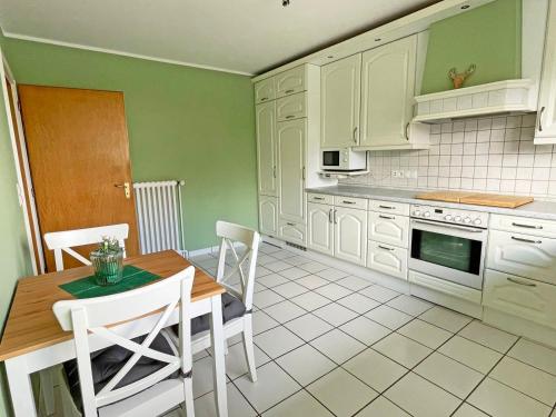 a kitchen with white cabinets and a table and chairs at Stadtoase in Süderbrarup