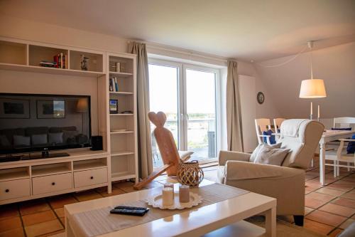 a living room with a tv and a couch and a table at Lieschenhüs in Kappeln