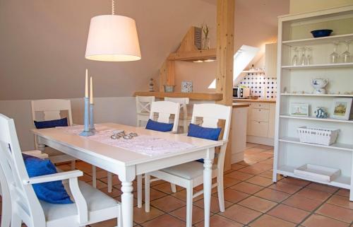 a dining room with a white table and chairs at Lieschenhüs in Kappeln