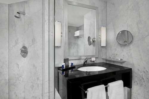 a bathroom with a sink and a shower with a mirror at The Park Tower Knightsbridge, a Luxury Collection Hotel, London in London