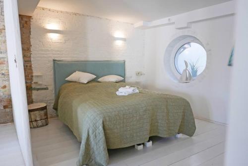 a bedroom with a bed with a green blanket and a mirror at Hafenheimat in Kappeln