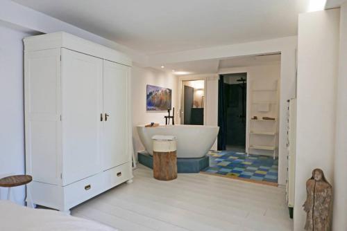 a white bathroom with a tub and a sink at Hafenheimat in Kappeln
