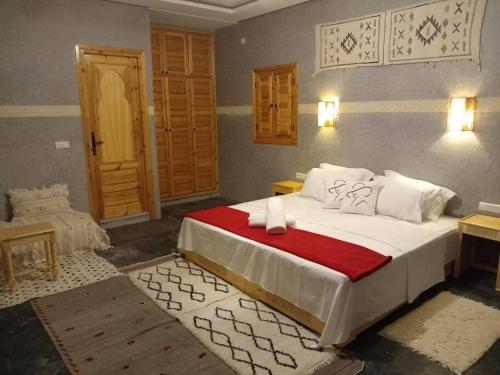 um quarto com uma cama grande e um cobertor vermelho em Bab JBEL em Marrakech