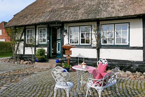 a house with a table and chairs in front of it at Ferienhaus Rikate in Kappeln